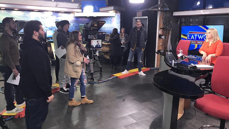 Students and studio staff look on at a live broadcast at the WTAJ news studio