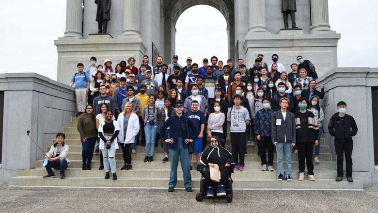 A large group of students standing on steps in front of the 宾西法尼亚 Memorial